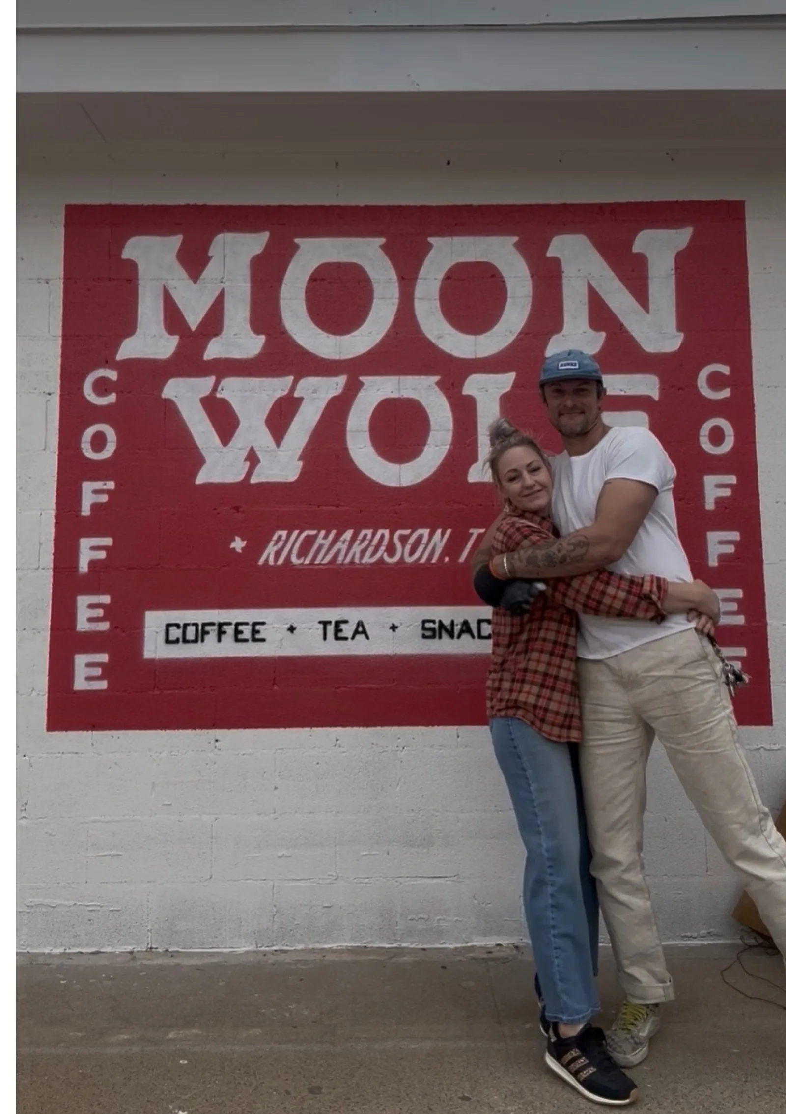 Sarah Ratliff and Stu Conry in front of the Moon Wolf cowgirl-on-wolf mural — collaborators on identity and motion.